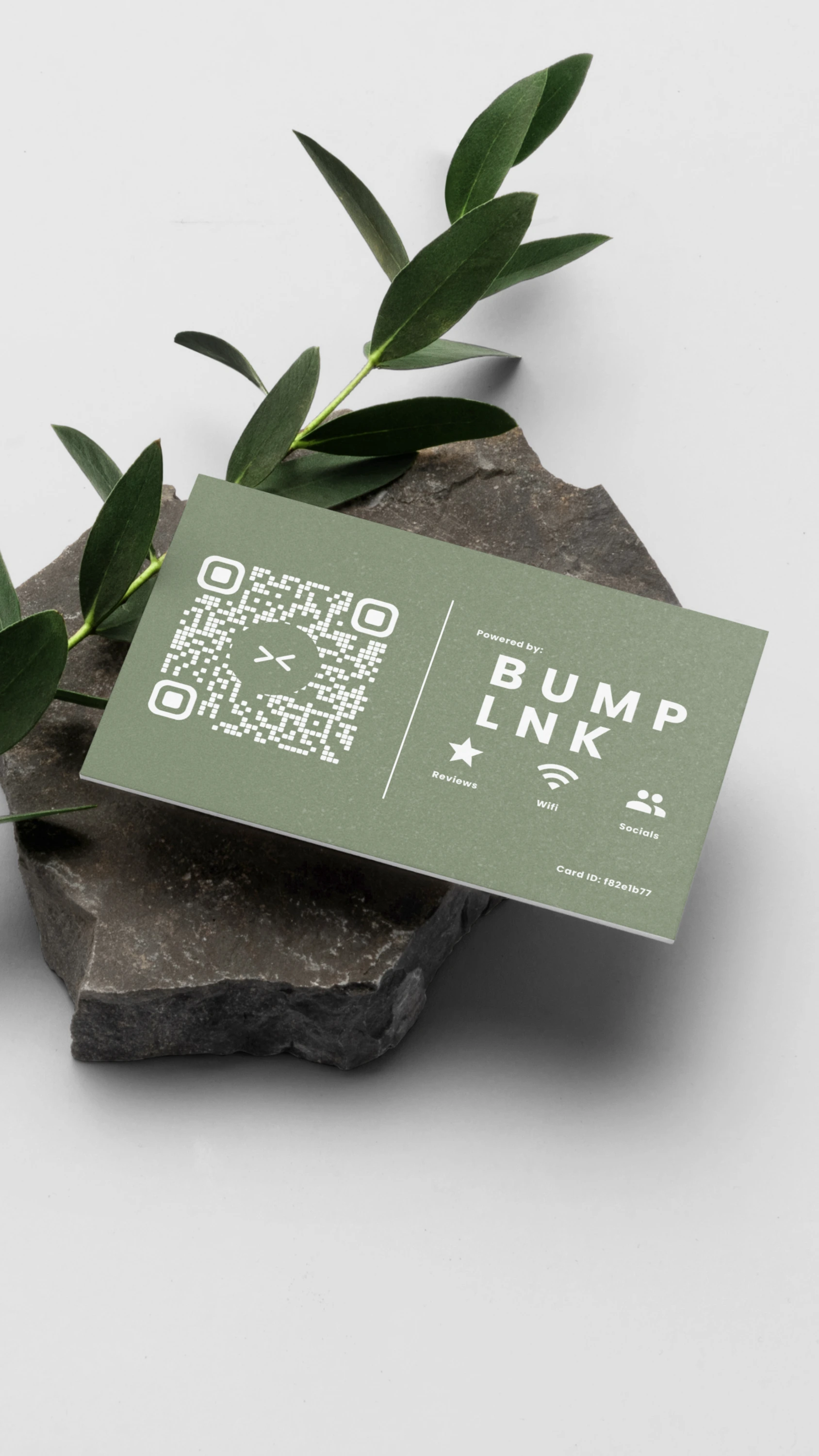 A green BumpLnk card on dark stone beside a leaf